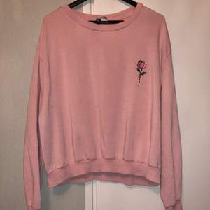 En fin och väldigt bekväm rosa sweatshirt med en ros på. Står storlek L men skulle säga mer som M