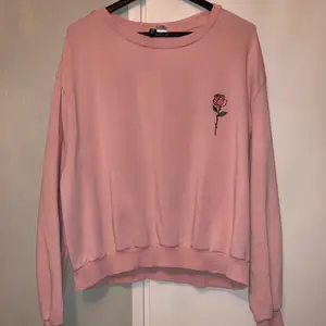 En fin och väldigt bekväm rosa sweatshirt med en ros på. Står storlek L men skulle säga mer som M