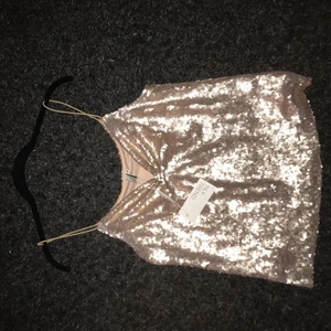 Festtopp  - Jättefin skimrande festtopp från nelly i storlek 34, passar perfekt till nyår.  Den är aldrig använd och prislappen kvar, köparen står för frakt