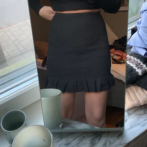 Svart kjol  - Svart kjol ifrån Nelly, storlek 36. Stretchigt material, längst ner är de en volang. Perfekt längd. Jag är 177cm. 