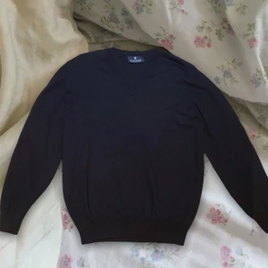 Stickad tröja.  - En svart/mörk blå stickad tröja med V-ringning. Perfekt för layering. Köpt secondhand. Kan passa XS-M beroende på önskad passform. Men står S på lapp. Fint skick, men desvärre ett litet hål på bröstet. Men syns inte mycket om man inte ”töjer ur det” (kan skicka bild!) (Därav priset). Köparen står för frakt. 💕