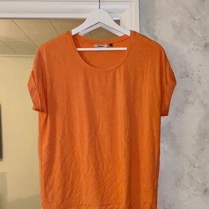 Orange T-shirt storlek S  - T-shirt i storlek S men känns lite som M… knappt använd men skön att ha på sig och fint skick ☺️