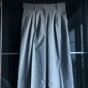 Gråa kostymbyxor med pressveck - Säljer mina snygga gråa kostymbyxor. De är i ett lätt skönt material vilket gör dem väldigt behagliga att använda. Jag är 164cm och de var lite långa på mig så passar någon perfekt som är några centimer längre. De är använda typ en gång så de är i ett väldigt bra skick. De är i storlek 38 från H&M för något år sedan. Säljer pga för liten storlek. 150kr + frakt