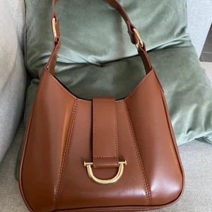 Brun axelväska - Brun axelväska från Asos, knappt använd så i perfekt skick :-) köpte för 300kr, säljer för 150kr. Frakt tillkommer!