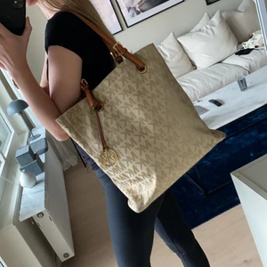 Michael Kors väska - Rymlig väska från Michael Kors som passar perfekt som skolväska eller liknande. Den är väl använd och har några fläckar men den har mycket kvar att ge eftersom väskan är i väldigt bra kvalitet. 