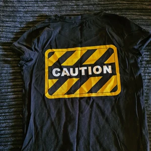 T shirt  - Säljer en riktigt snygg t shirt med Caution tryck på ryggen. Storlek XXS men passar mig som har XS/S Säljer i mycket fint skick 70 kr