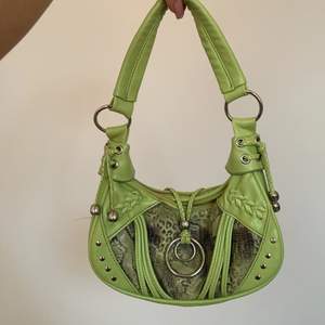 En limegrön väska som går att ha under armen. Riktigt y2k😍 med orm-mönster och gulliga detaljer