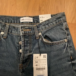 Oanvända Zara jeans storlek 34  - Ett par fina helt oanvända jeans från Zara, köpta i Frankrike för 39 €. Säljes då de är för små för mig. De är ganska långa i modellen och har slits längst ner på båda sidor.