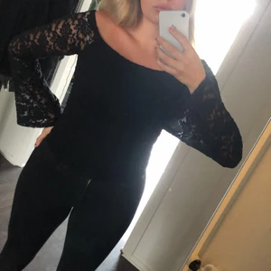 Blus  - Svart blus med spets och vidda trumpet armar 