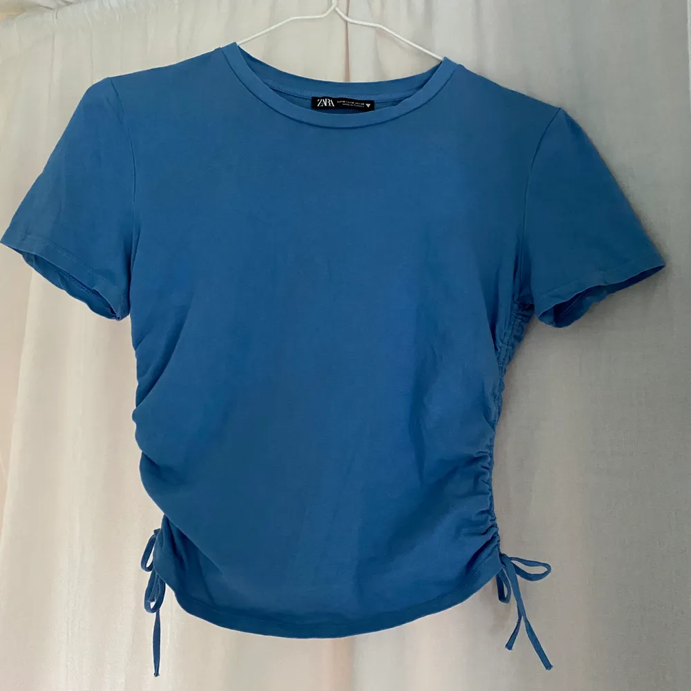 Jag säljer denna blåa topp med dragsko på båda sidor för 20kr + frakt. 💙 Toppen är från Zara i storlek Medium men skulle säga att den passar Small. Jag säljer denna i fint skick för att den är för liten för mig. . T-shirts.