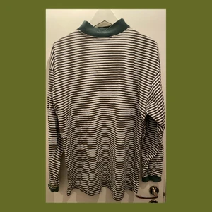 Randig tröja - Grön och vit randig tröja med en liten krage. Den är tunn och skön! Finns lite slitningar vid kragen.