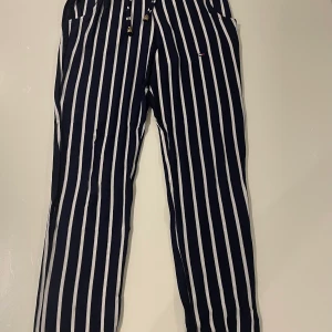 Byxor strl small  - Vit mörkblå randiga byxor i small säljes 