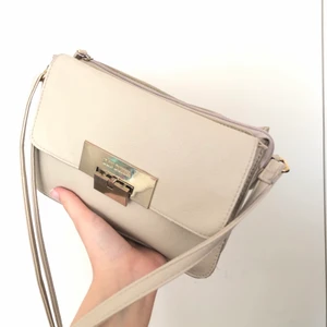 Axelremsväska Don Donna  - Beige axelremsväska från Don Donna i bra skick. Endast lite miss färgningar i metall delen längst fram. Kan mötas upp & frakta! Kunden står då för frakten. Hör av er för fler bilder🤍
