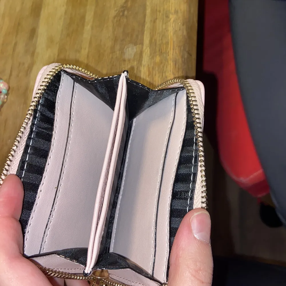En ny Victoria secret plånbok använd ca 2 gånger så är i ny skick, baby rosa färg med guld detaljer. 7 små kort fack och sen 2 st större. Dragkedjan är kvar med sin detalj. . Accessoarer.