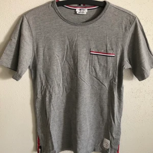 Thom Browne Classic Pocket Tee - Women’s Thom Browne Classic Pocket T-Shirt  Size small, regular small fit.  Excellent condition, no flaws or damage.  DM if you need exact size measurements.   Buyer pays for all shipping costs. All items sent with tracking number.   No swaps, no trades, no offers. 