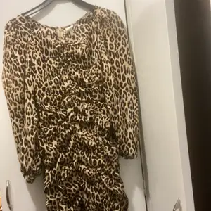 ”Skrynklig” klänning med puffärmar i leopardmönster från h&m. Aldrig använd.