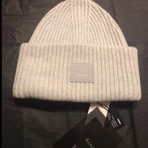 Acne mössa vit - Nästan helt oanvänd acnemössa. Har precis tvättas på kemtvätt så det finns absolut inga tecken på användning. Köptes förra året på NK men kom aldrig till användning så säljer den nu eftersom jag inte känner att jag kommer ha på mig den i vinter heller