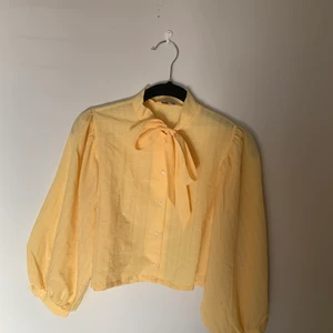 blus med rosett - somrig knytblus med lite harry styles vibbar tkr jag :)) älskar denna men har knappt använt den vilket är vrf jag säljer, nyskick! köpt på beyond retro för 2 år sen, står storlek 14 men tycker den är ganska liten i storleken