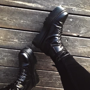 Svarta platåkängor  - Ett par svarta platåkängor i fejkläder med snörning och dragkedja. Använda färre än fem gånger, i mycket bra skick! Finns några små repor på skornas inre sidor (se bild) samt lite nött på plös men det syns ingenting när skosnörena är där.