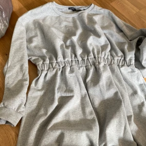 Klänning  - Grå sweatshirtklänning med åtdragning i midjan. Supermysig en sommarkväll. 