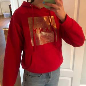 Säljer en så fin röd hoodie med guld tryck i stl XS.   Den är i fint skick och nypris är ca 500 kr. Köpt i USA på Donna Karen New York för ca 3 år sedan. 