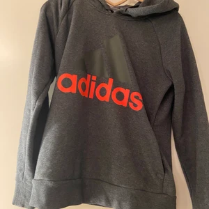 Grå adidas hoodie - Grå adidas hoodie som är använd ytterst få gånger. Säljs för 230 kronor då den är i bra Skick. Storlek S men passar större och mindre