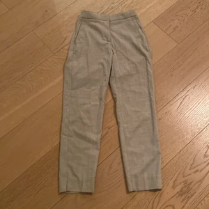 Kostymbyxor, beiga  - Intressekoll på dessa väldigt fina kostymbyxor från H&M. De är beiga. Det är en liten slits på båda benen, ca 2 cm lång. De är i väldigt bra skick. Det är resor bak på byxorna. Storlek 32. Nypris ca 200kr, säljer för 100kr, kanske går att pruta något. De är midwaist. Frakt ingår ej. Kan skicka fler bilder vid intresse. 