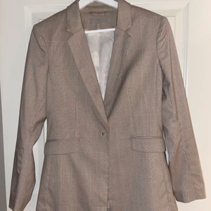 En beige kavaj från H&M - En oanvänd beige kavaj, med rosa detaljer i storlek Small