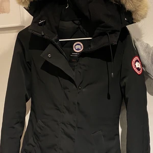 Nyskick Canada Goose jacka - Säljer en svart lång Canada Goose jacka i storlek 2XS, kvitto medföljs.  