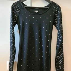 Festklänning Bikbok strl M. - Kort figursydd festklänning med stenar och lång ärm från Bikbok i strl M som är använd vid ett tillfälle.