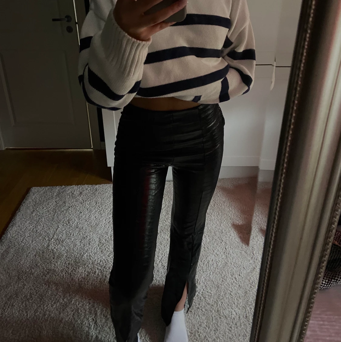 Svarta skinnbyxor med mönster och slits