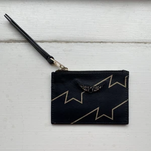 Zadig korthållare  - En Zadig Voltaire korthållare i svart med guld detaljer.⭐️⭐️⭐️ Både med fack för kort och en öppning med dragkedja. Sparsamt använt. Säljer pga använder inte längre.