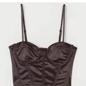 Korsett topp - Brun korsett topp i satin från hm. Köp på plick men säljer pga för liten för mig. Finns inte på hemsidan eller i affär längre! Storlek XS/34. Säljer för 200+frakt.