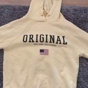 En gul hoodie med tryck, köpt för 300 kr. Bra skick och mjuk på insidan. Använder aldrig längre                    Köpare står för frakt