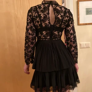 Black festive lace dress - A black open back lace dress with layers. Long sleeves, very elegantti and Classic. Never used. 