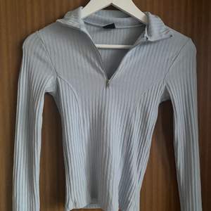 Ljusblå tröja med zip up, storlek xs från ginatricot 