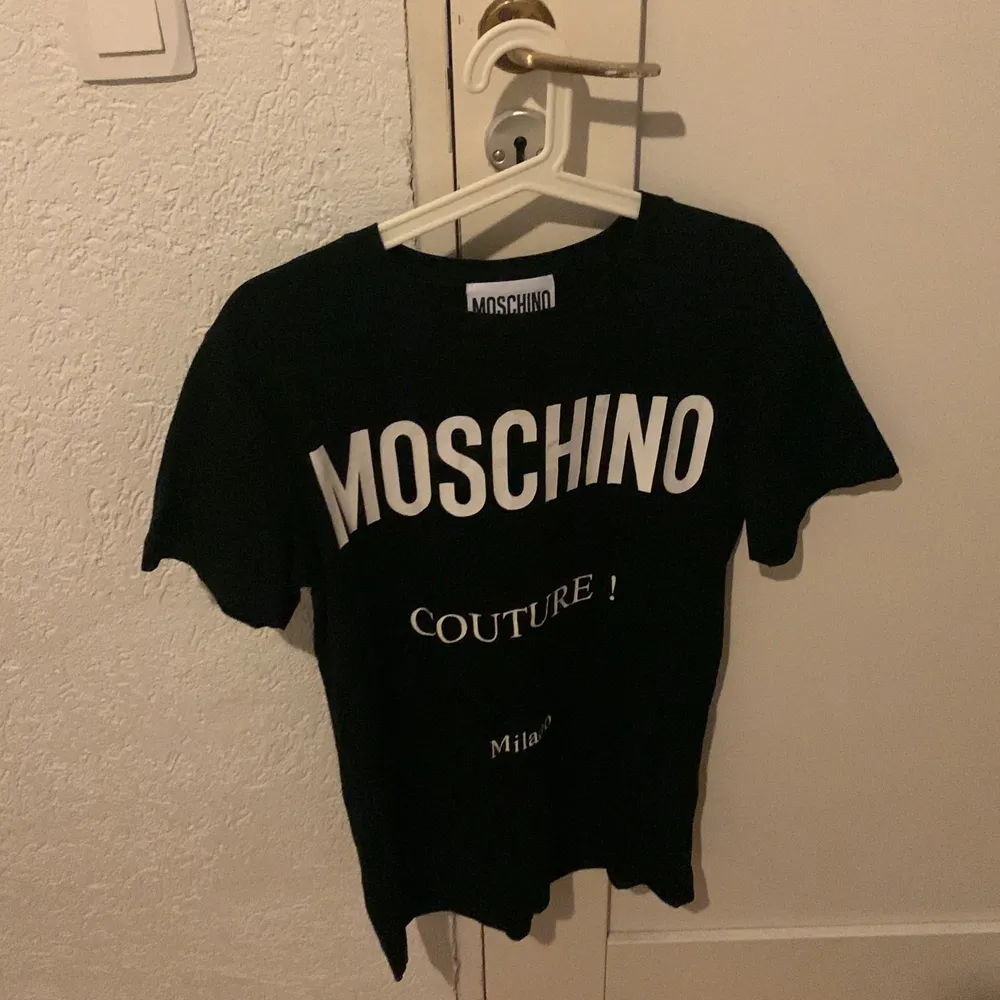 100% äkta Moschino T-shirt. Använd men fortfarande i bra skick. Originalpris är 1399kr.. T-shirts.