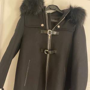 En svart fin kappa som är köpt på ZARA.