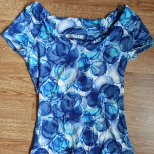 Blus med blå bubblor från Dika - En riktigt stretchig blus som går att bära på många olika sätt. Ringningen är rätt så bred. Har burits enstaka gånger. I storlek XS (EUR) men kan bäras av S och M också. 💙