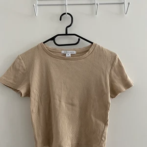 Nudelucy Beige cropped tshirt  - En snygg vanlig beige t-shirt. Kroppad och i bra skick, knappr använd. Storlek M men skulle säga att den nästintill är S då den är rätt tight/liten i storleken. Köparen står för frakt 🧡