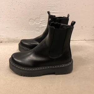 Kängor, Nelly.com - Svarta kängor med vit söm utanpå från Nelly. Använda endast två gånger därav fint skick. Nypris: 599kr