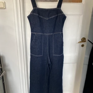 Byxdress i denim från weekday - Cool byxdress i mörkblå denim från weekday. Stora fickor fram och dragkedja bak. Använd en gång. Pris inkl.frakt.