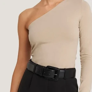 NA-KD topp med en axel - En beige topp med en axel från na-kd. Använd fåtal gånger eftersom att den är förstor för mig. Kom privat för mer bilder💞