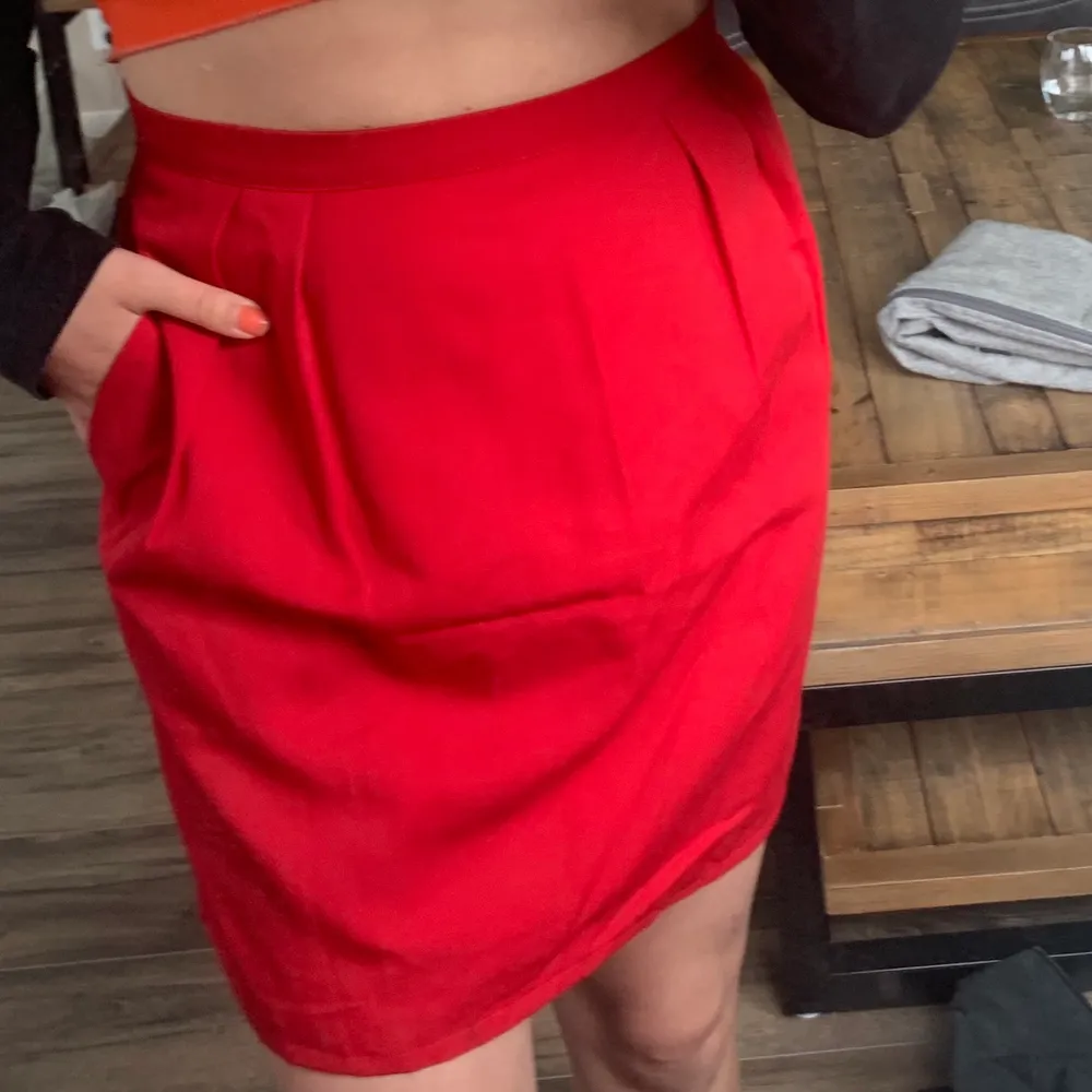 Röd kjol i storlek S, köpt på beyond retro men aldrig använd av mig. Kjolen har fickor och slutar en liten bit ovanför knäna på mig (är 164 cm).. Kjolar.