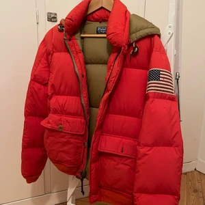 Orange vinterjacka - Orange vinterjacka från Ralph lauren. Två små hål i luvan. Vid post tillkommer frakt.