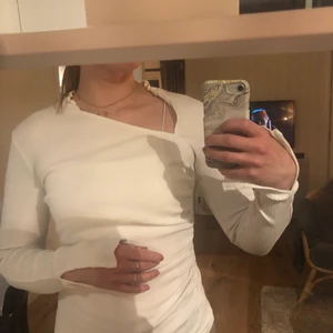 Långärmad ribbad topp  - Vit, långärmad topp i stl S. Lite längre i ärmarna med en snygg sned hals. Liten slits vid ärmarna med. Använd fåtal ggr 