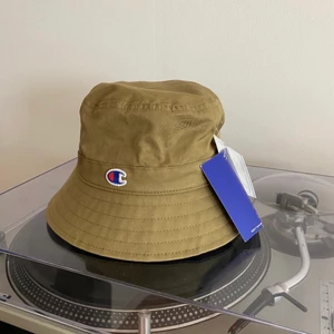 Champion bucket hat - NY (Nypris 450.-) - Brand new and never used Champion hat, tags still on. Size S which I would say can fit only girls.  Take a look at my other items as I combine deliveries.  Thank you :)