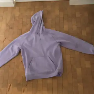 En lila carhartt hoodie köpt från Zalando. Den är helt ljuslila förutom ett carhartt märke nere vid ärmen. Köparen står för frakt.