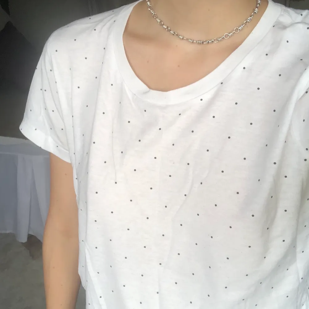En vit t-shirt med små svarta prickar. Jättegullig! . T-shirts.