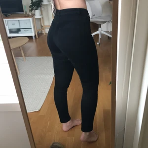 Svarta jeans - Svarta jeans från Monki, supersköna! Jag är 165cm från referens och de är i storlek 26 men passar en XS-S skulle jag säga. På vardera sida av låren är det hål (precis där låren gå ihop), syns på bild 3. Går med säkerhet att klippa av till fina jeansshorts.